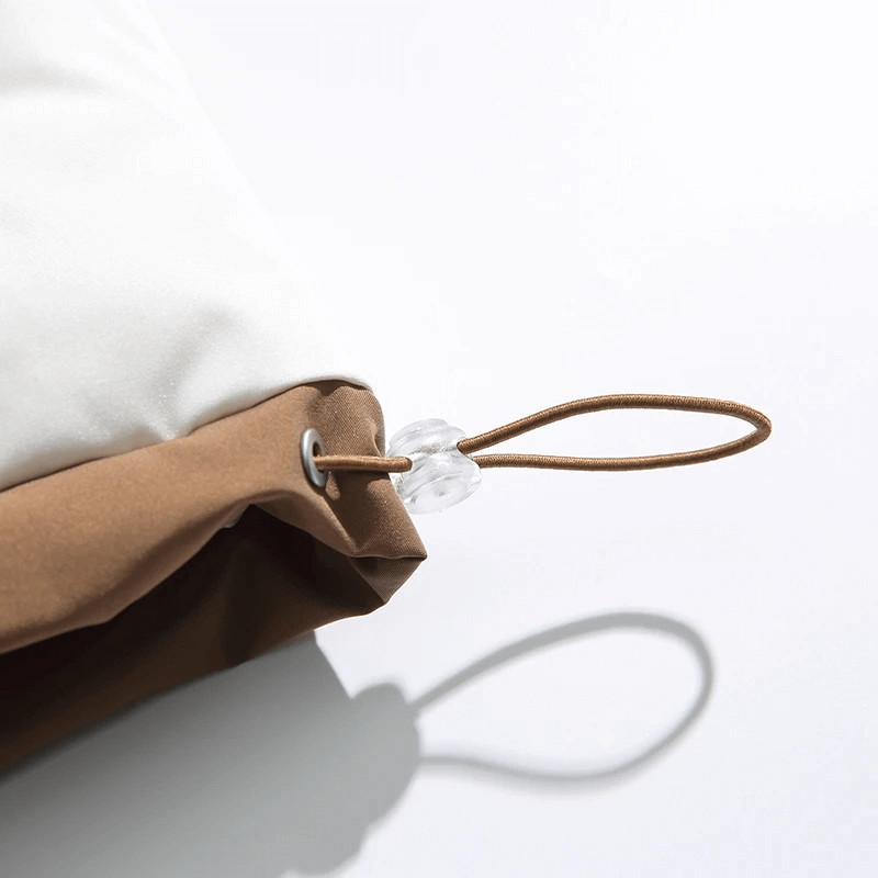 Close-up of a brown and white jacket hood with drawstring detail, emphasizing style and functionality.